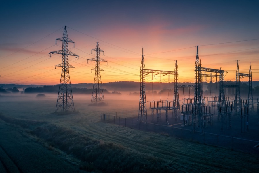 Sunrise over grid substation in morning mist
