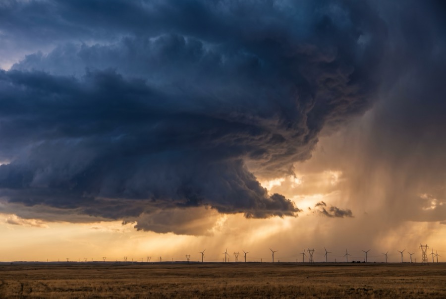 Storm building over wind turbines and transmission lines